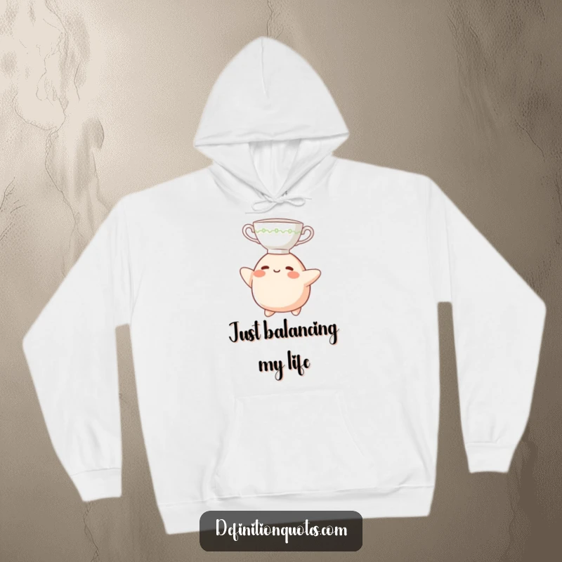 Funny Hoodie: A small, cheerful blob character balancing a teacup on its head, embodying delightful clumsiness.