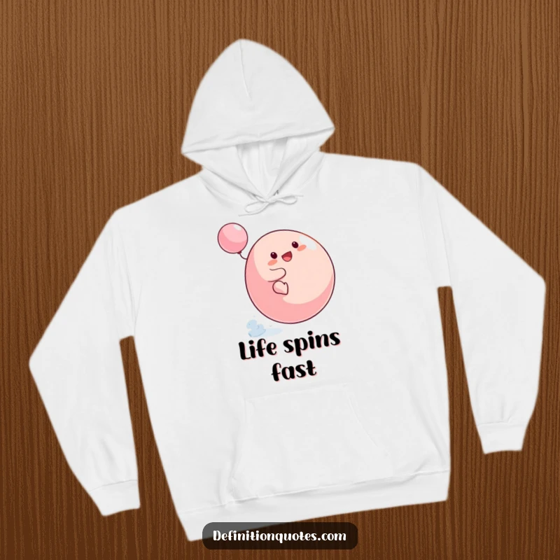 Funny Small Blob Hoodie showing the character's comical struggle to ride a spinning top, offering comfort and humorous entertainment.