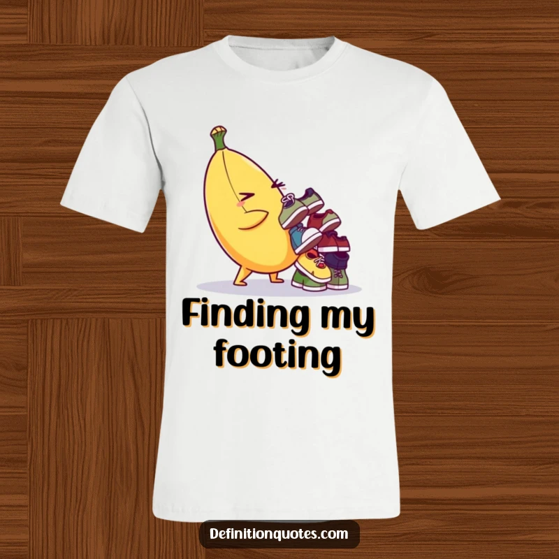 Funny T-shirt of a winking banana character precariously balancing a stack of tiny, odd shoes. Humorous and whimsical.